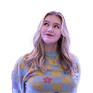 A photograph of CHAOS Radio presenter Bryna Jordan; she is wearing a yellow and grey checked jumper, with intermittent red flowers in the pattern, and a silver necklace.