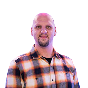 A photograph of CHAOS Radio presenter Henry Rosewall; he is wearing an orange, white, and black checked shirt.