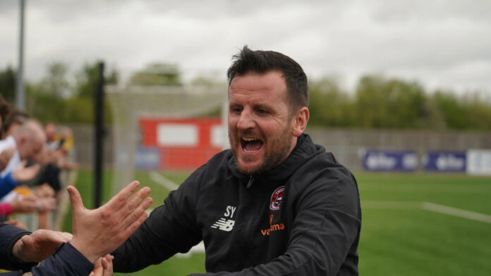 a photograph of Truro City FC's Yetton celebrating with the crowd on the pitch.